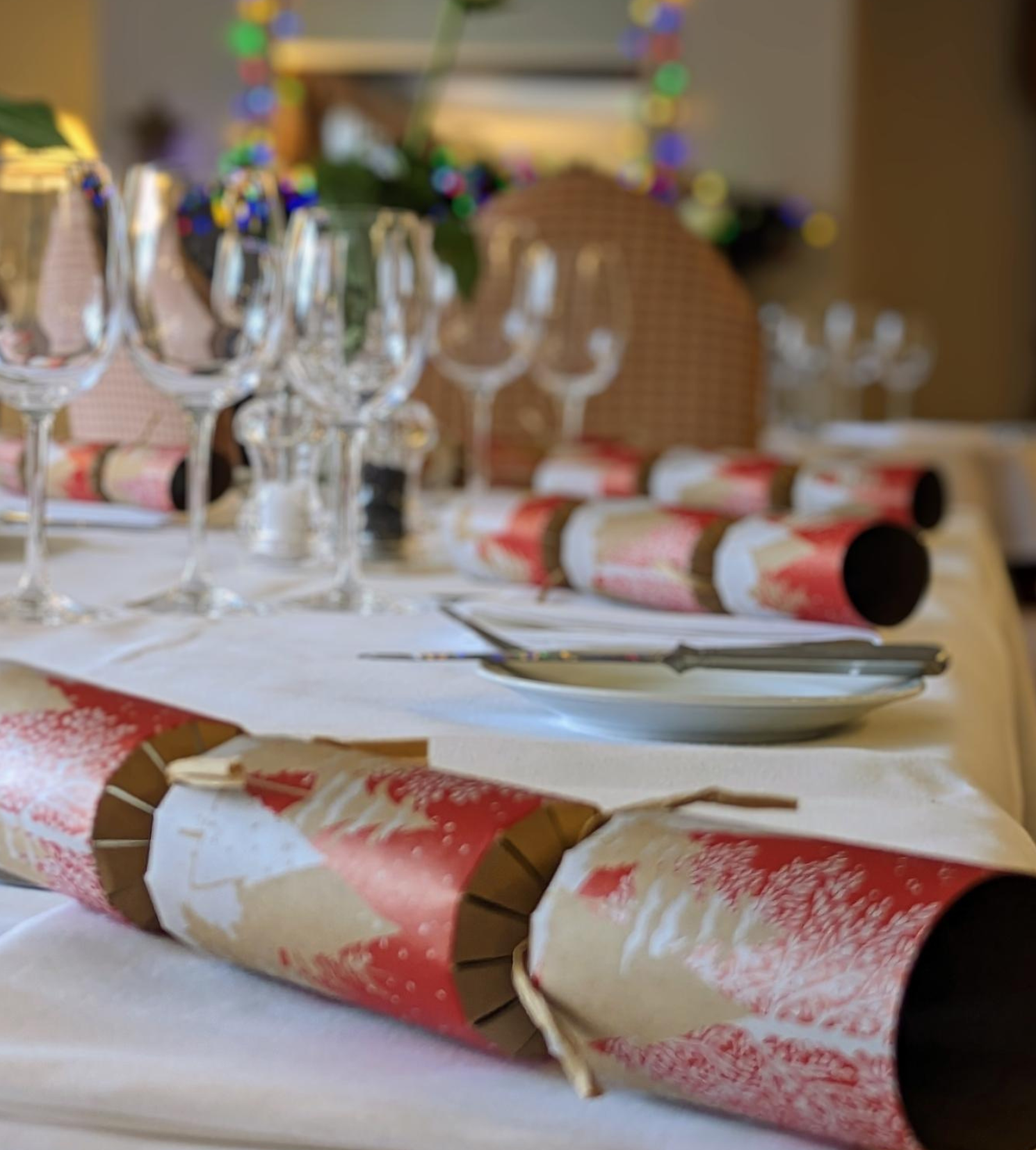 Festive table setting with Christmas crackers and glassware