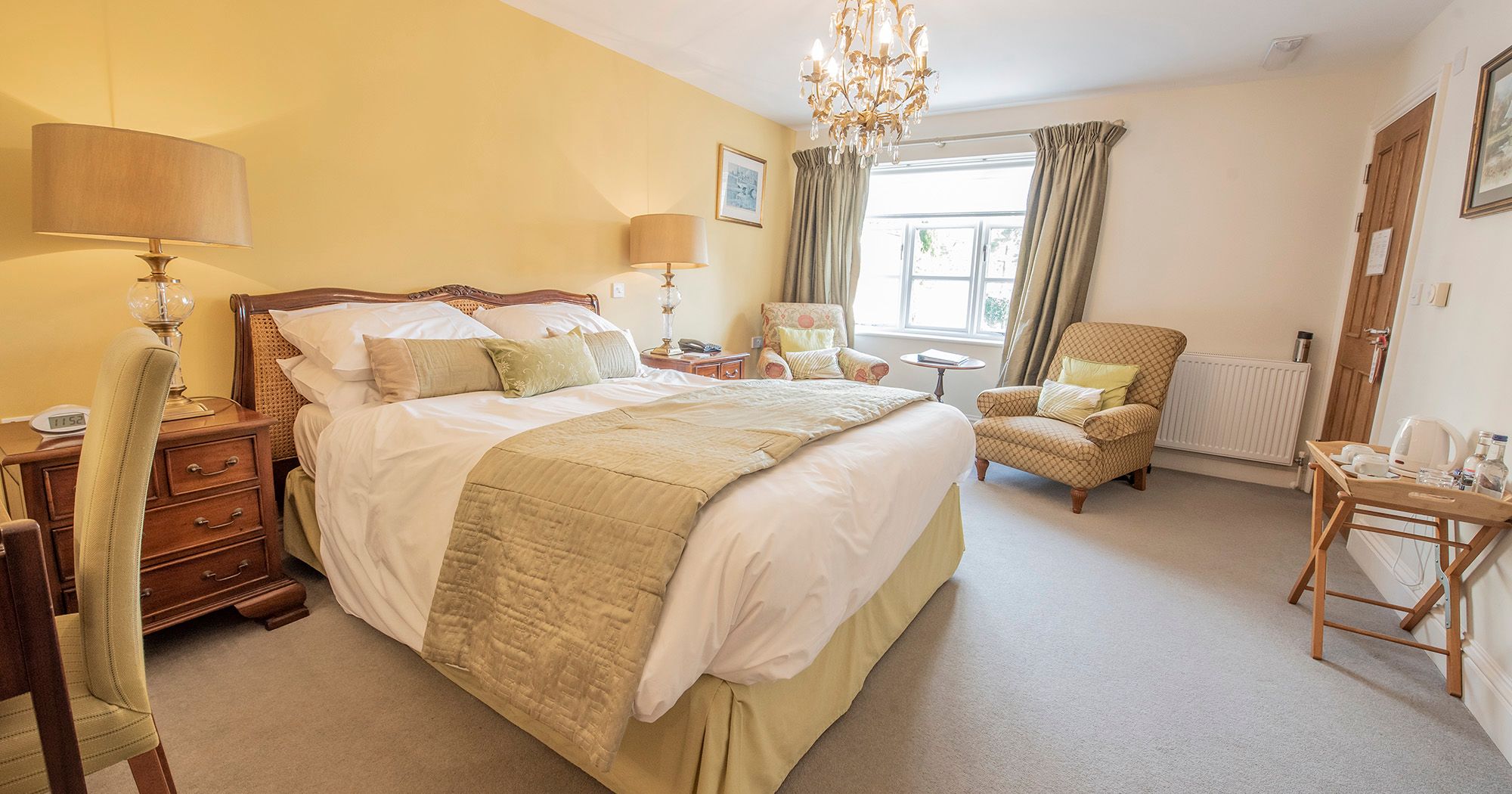 hotel room in light yellow hues with crystal chandelier