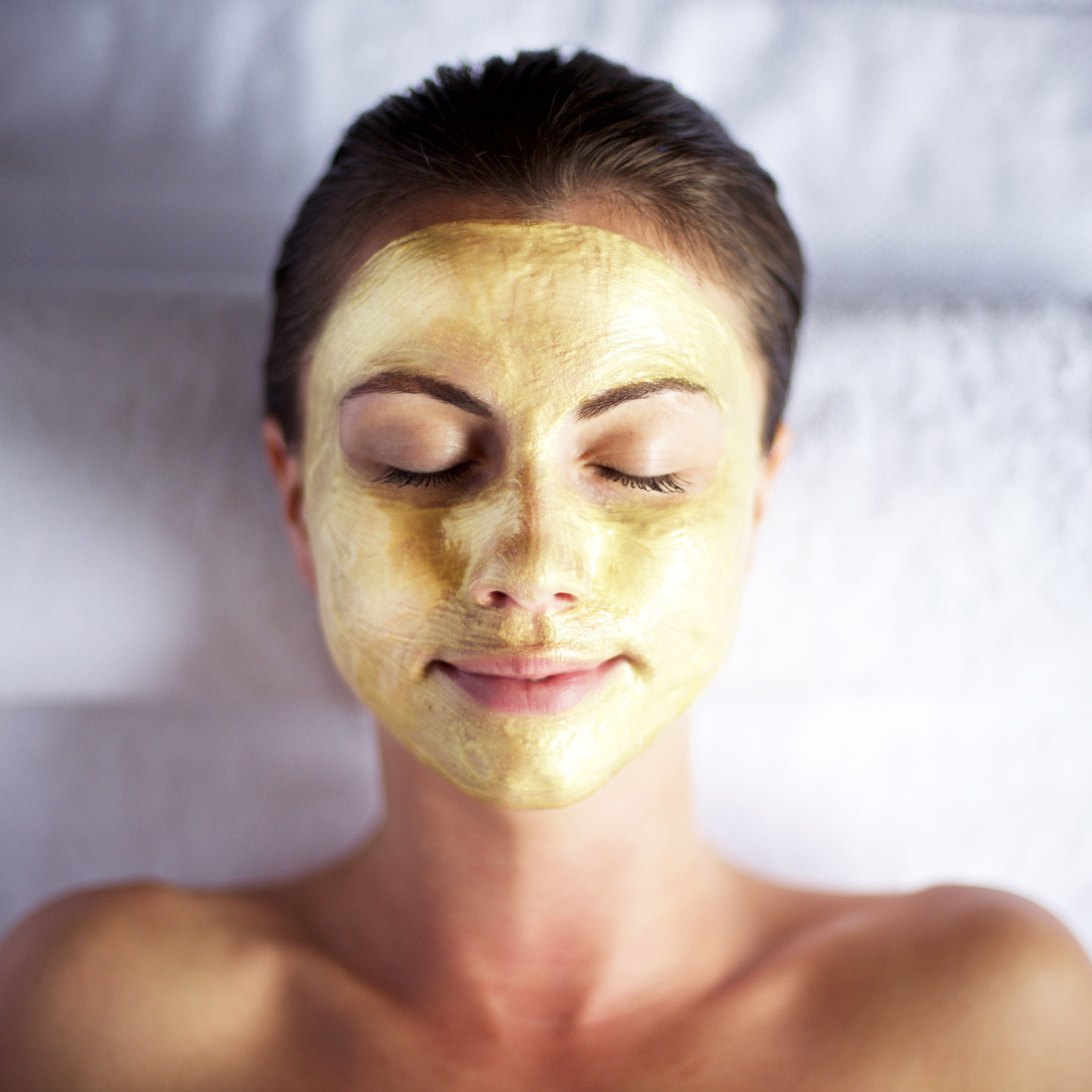 Woman relaxing with a yellow facial mask applied to her face