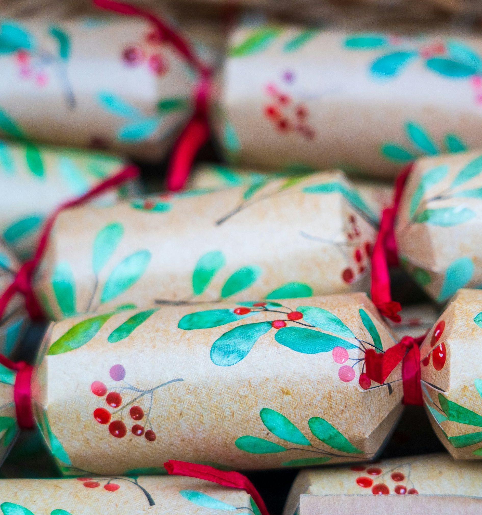 Close-up of decorative Christmas crackers with green leaves and red berries