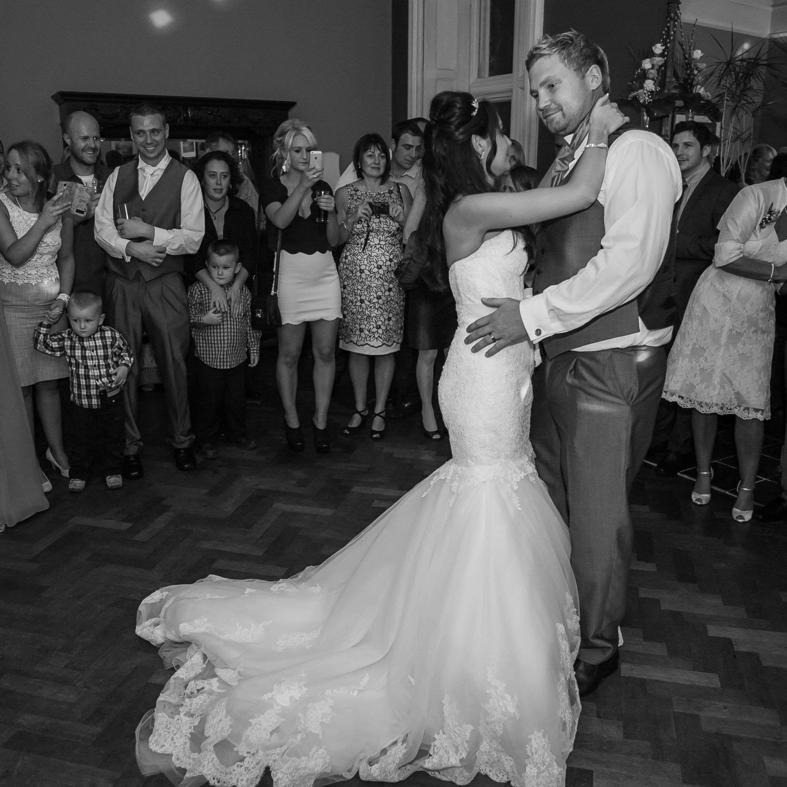 Bride and groom dancing surrounded by wedding guests