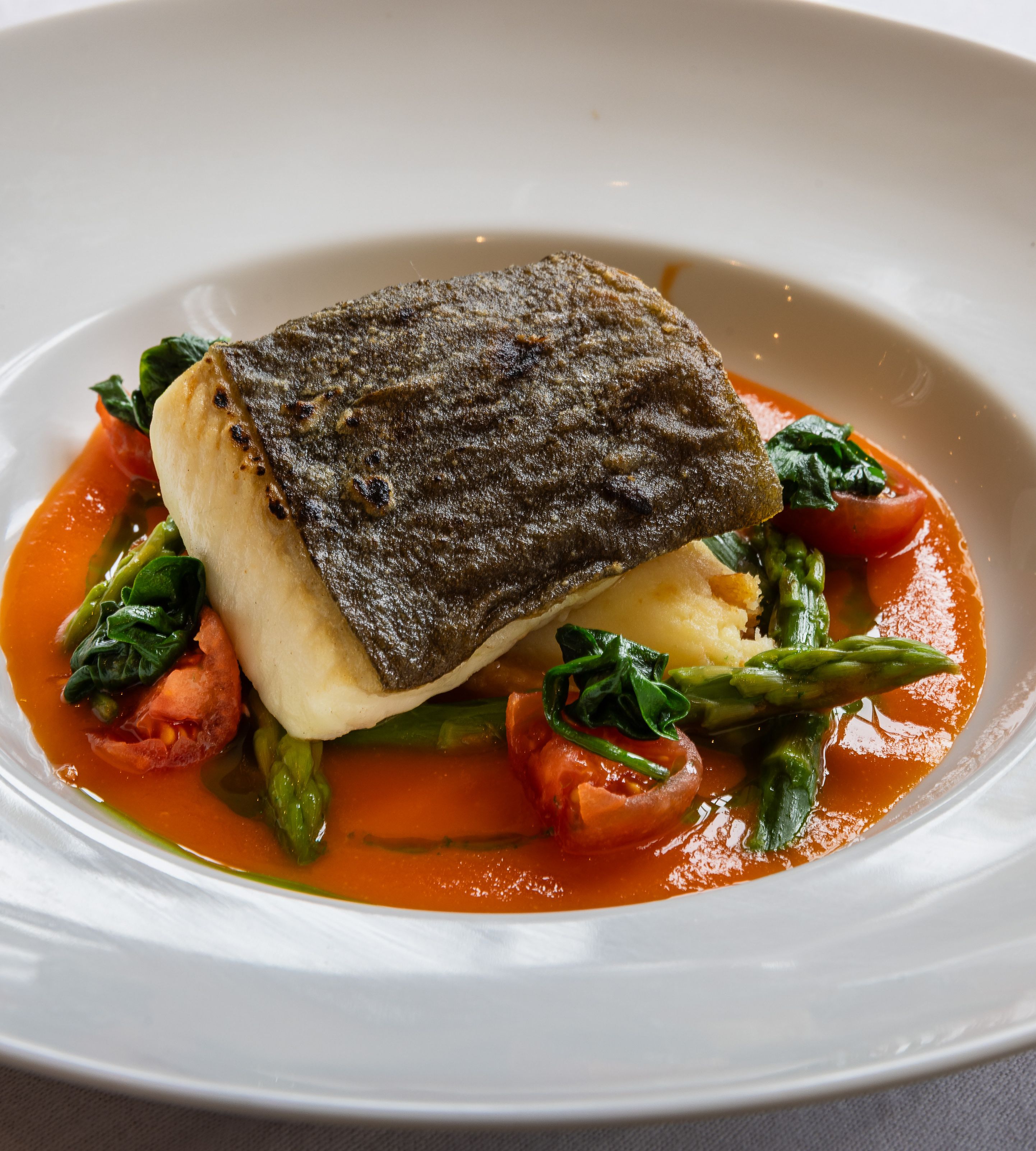 Plated seared fish fillet with vegetables and sauce