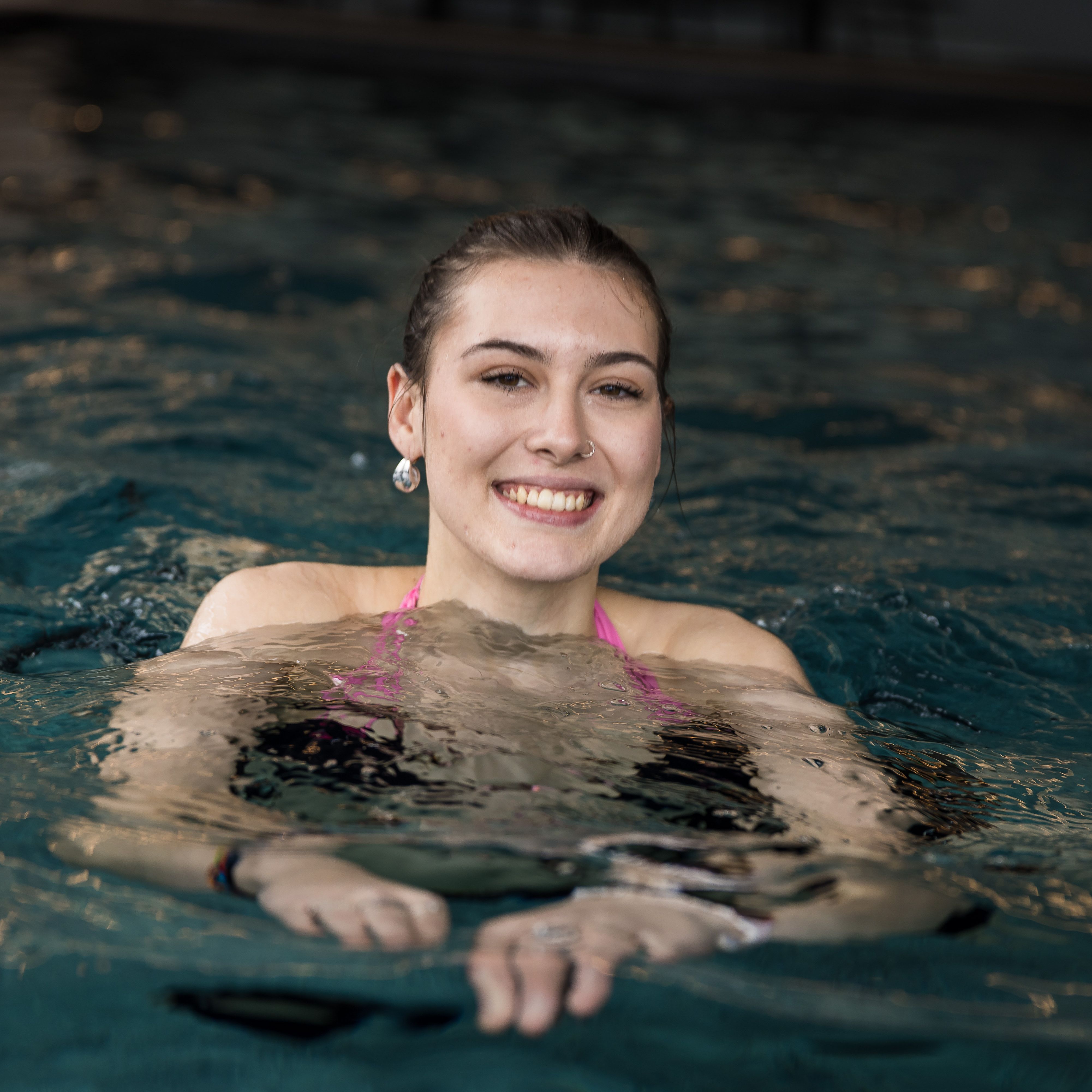 Smiling woman swimming in an indoor pool