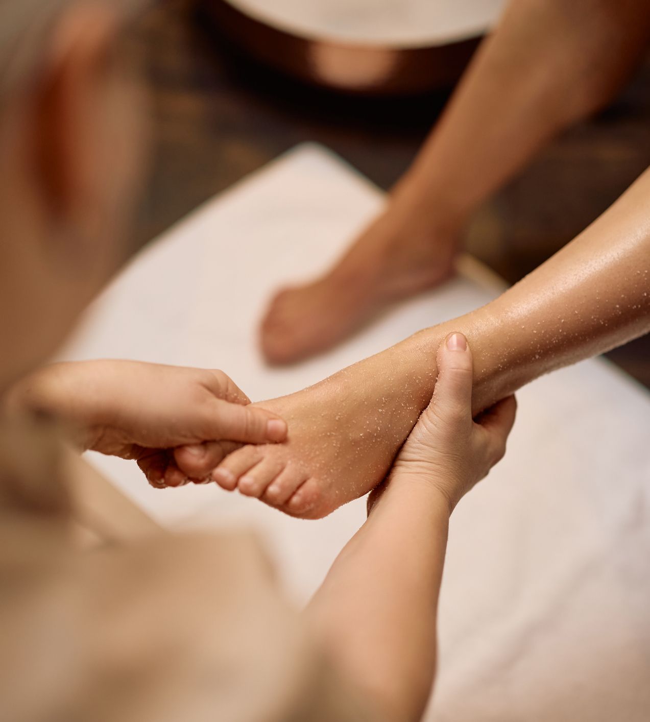 Close-up of a person receiving a foot massage at a spa