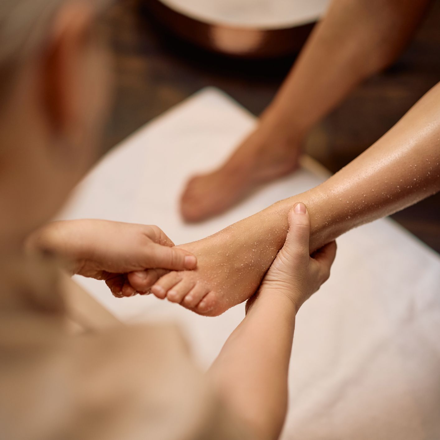 Close-up of a person receiving a foot massage at a spa
