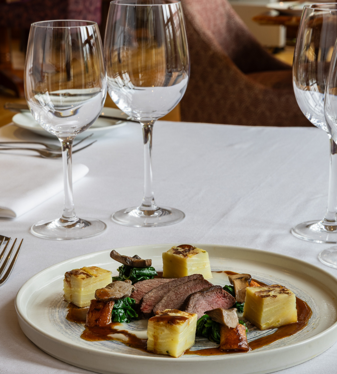 Gourmet plated dish with glassware on a restaurant table