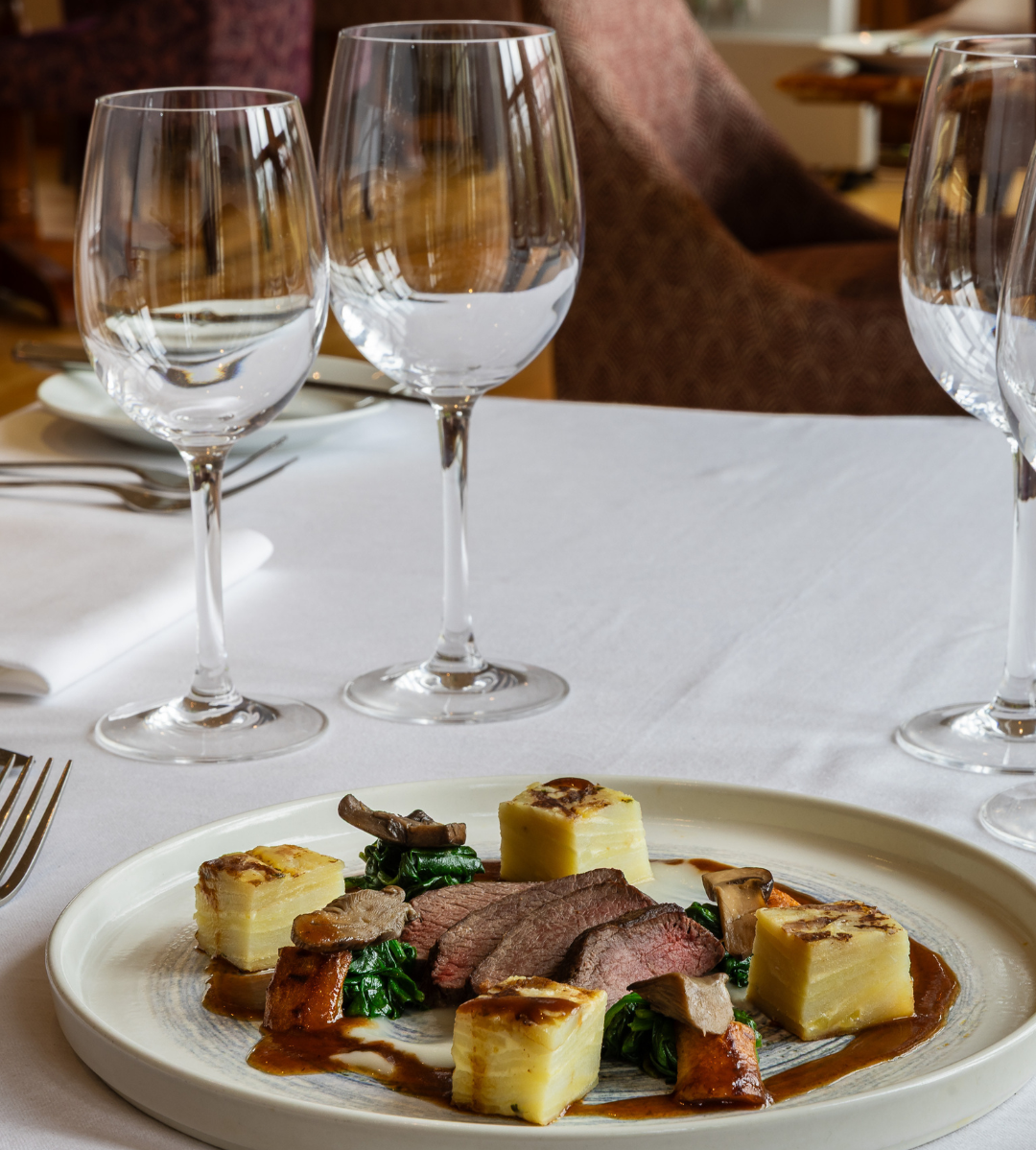 Gourmet plated dish with glassware on a restaurant table