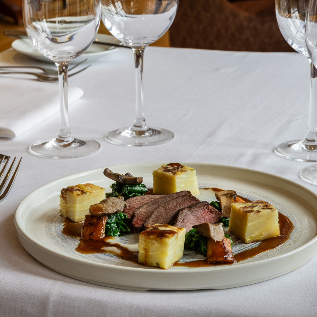 Gourmet plated dish with glassware on a restaurant table