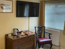 Smart TV, Chest of Drawers, Kettle and Hospitality Tray and Chair by side of window in Bedroom 1