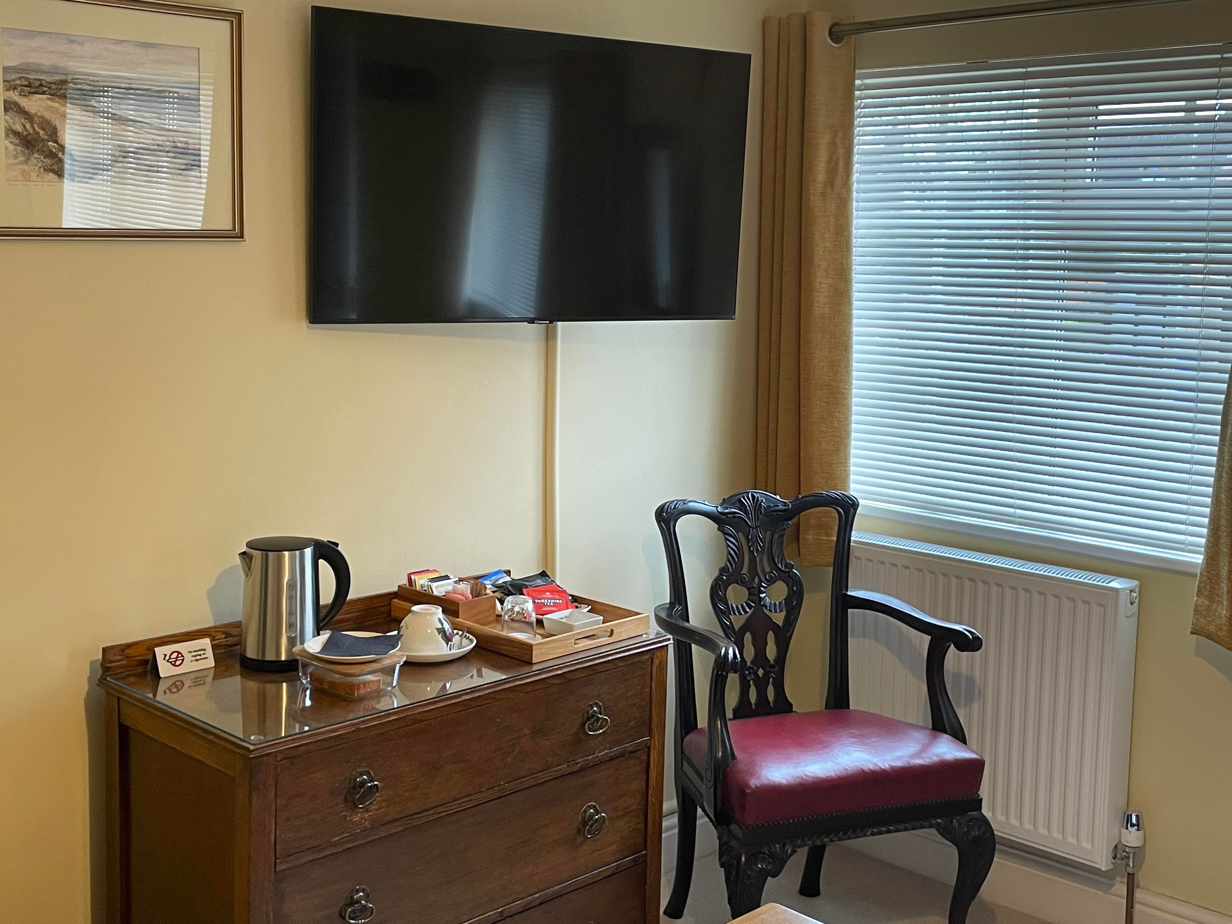 Smart TV, Chest of Drawers, Kettle and Hospitality Tray and Chair by side of window in Bedroom 1