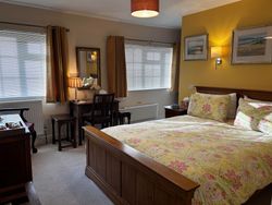 Bedroom 1 from door showing kingsize bed, dressing table, windows, pictures on wall and chest of drawers