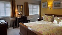 Bedroom 1 from door showing kingsize bed, dressing table, windows, pictures on wall and chest of drawers