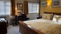 Bedroom 1 from door showing kingsize bed, dressing table, windows, pictures on wall and chest of drawers