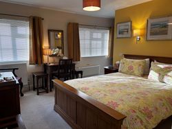 Bedroom 1 from door showing kingsize bed, dressing table, windows, pictures on wall and chest of drawers