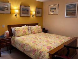 Kingsize bed of Bedroom 1with bedside tables, lights and pictures