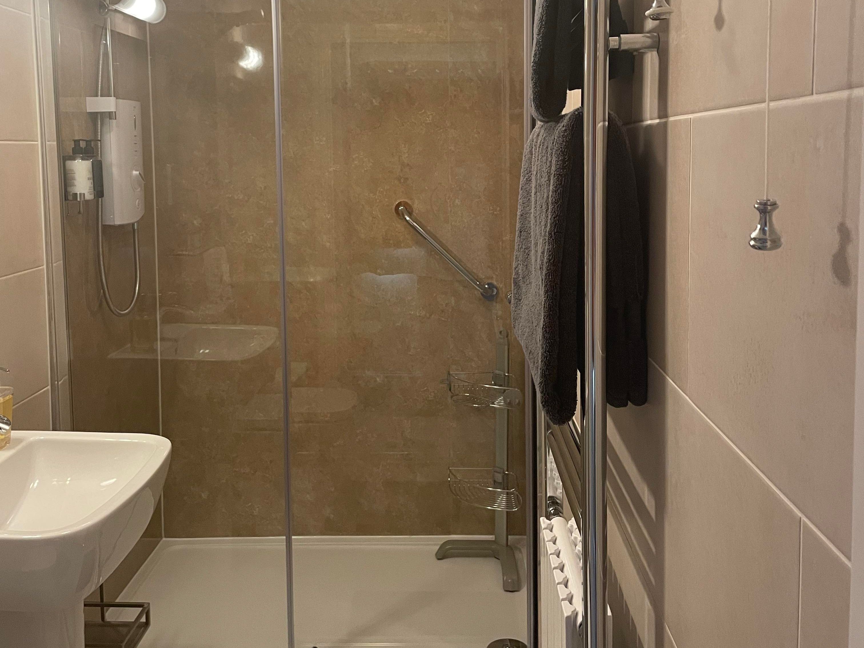Shower, towels on heated towel rail and sink