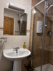 Shower, wash basin and mirror in the en-suite of Bedroom 2