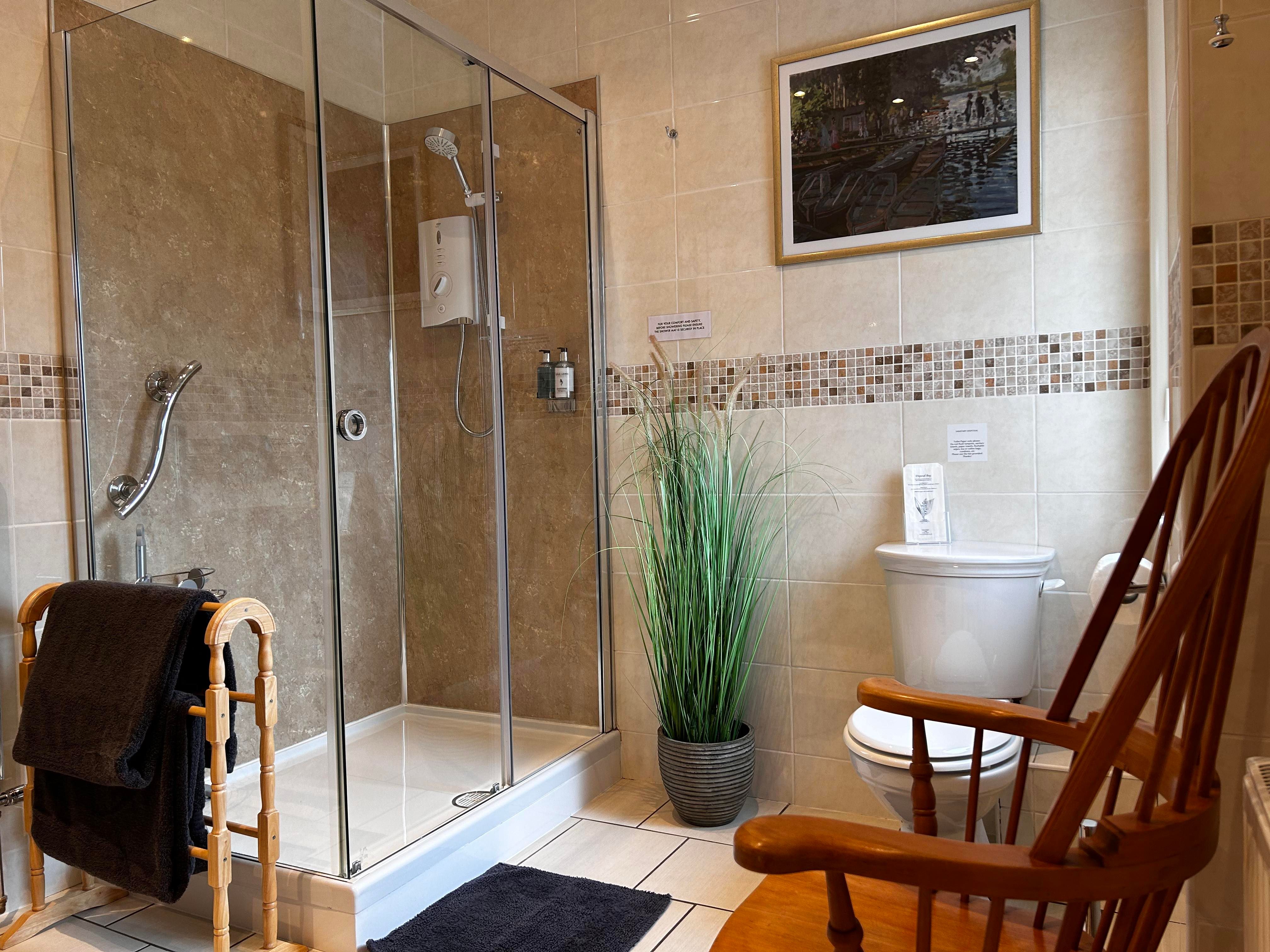 Large shower, chair and toilet in private bathroom for Bedroom 3