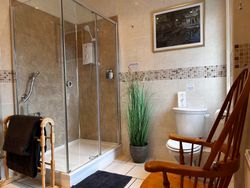 Large shower, chair and toilet in private bathroom for Bedroom 3