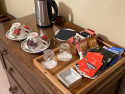 Hospitality tray, kettle, cups and saucers, biscuits and cake
