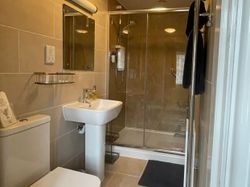 Bedroom 1 en-suite with shower, wash basin, toilet and centrally heated towel rail