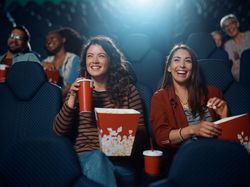 Friends sat in the theatre with popcorn