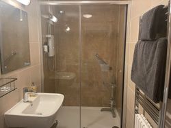 Shower, sink and towels on heated towel rail in Bedroom 1 ensuite