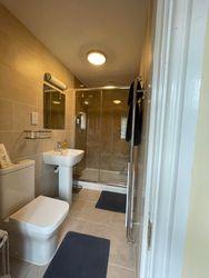 Shower, wash basin, mirror toilet and towel rail in the en-suite of Bedroom 1