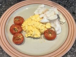 smoked haddock and scrambled eggs with roasted tomatoes on a plate