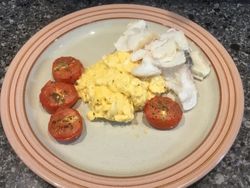 smoked haddock and scrambled eggs with roasted tomatoes on a plate