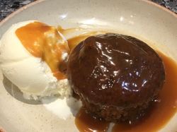 sticky toffee pudding in a bowl with ice-cream