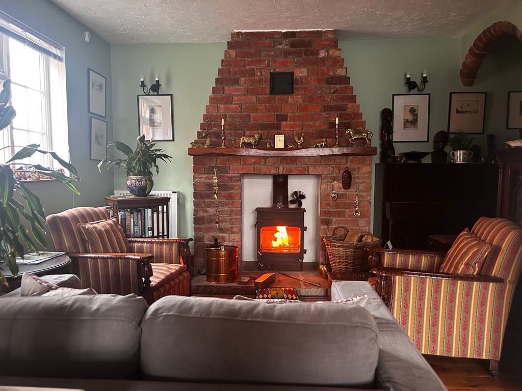 Seating for guests in the Dining Room in front of a fire in the log burner