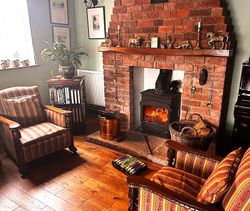Seating for guests in the Dining Room in front of a fire in the log burner