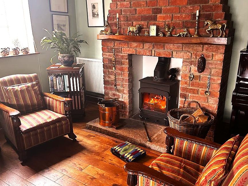 Seating for guests in the Dining Room in front of a fire in the log burner