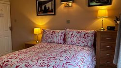 Double bed, side tables, lights, pictures and door of Bedroom 2