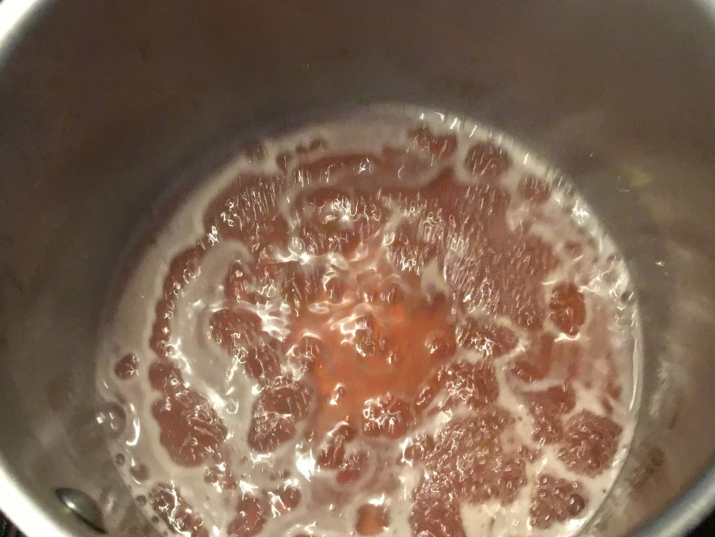 Pan with rhubarb juice and honey simmering