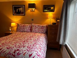 Double bed in Bedroom 2 with bedside table and lamps