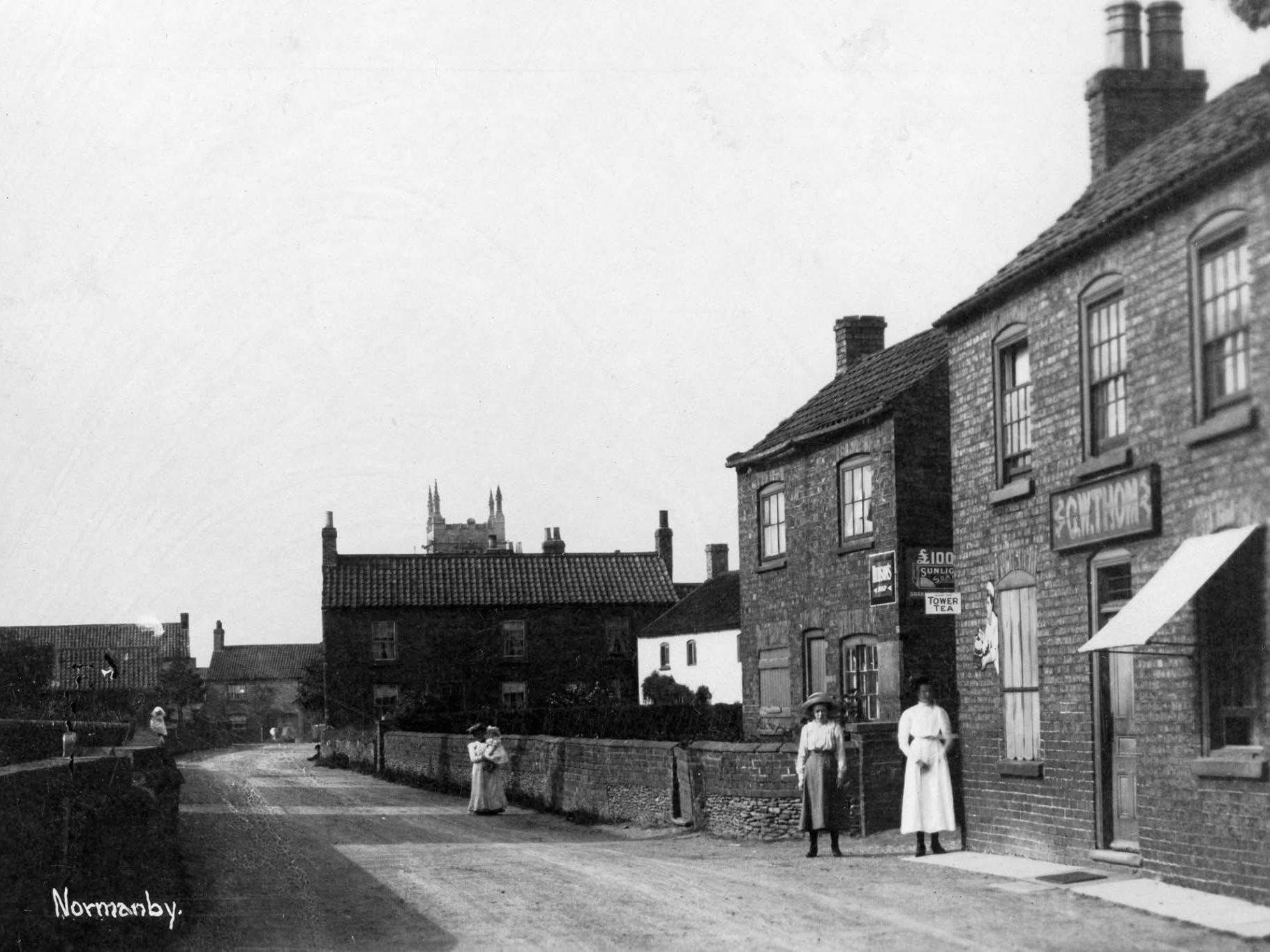 Picure of the front of The Old Posthouse from late 19th early 20th century with various people in the street