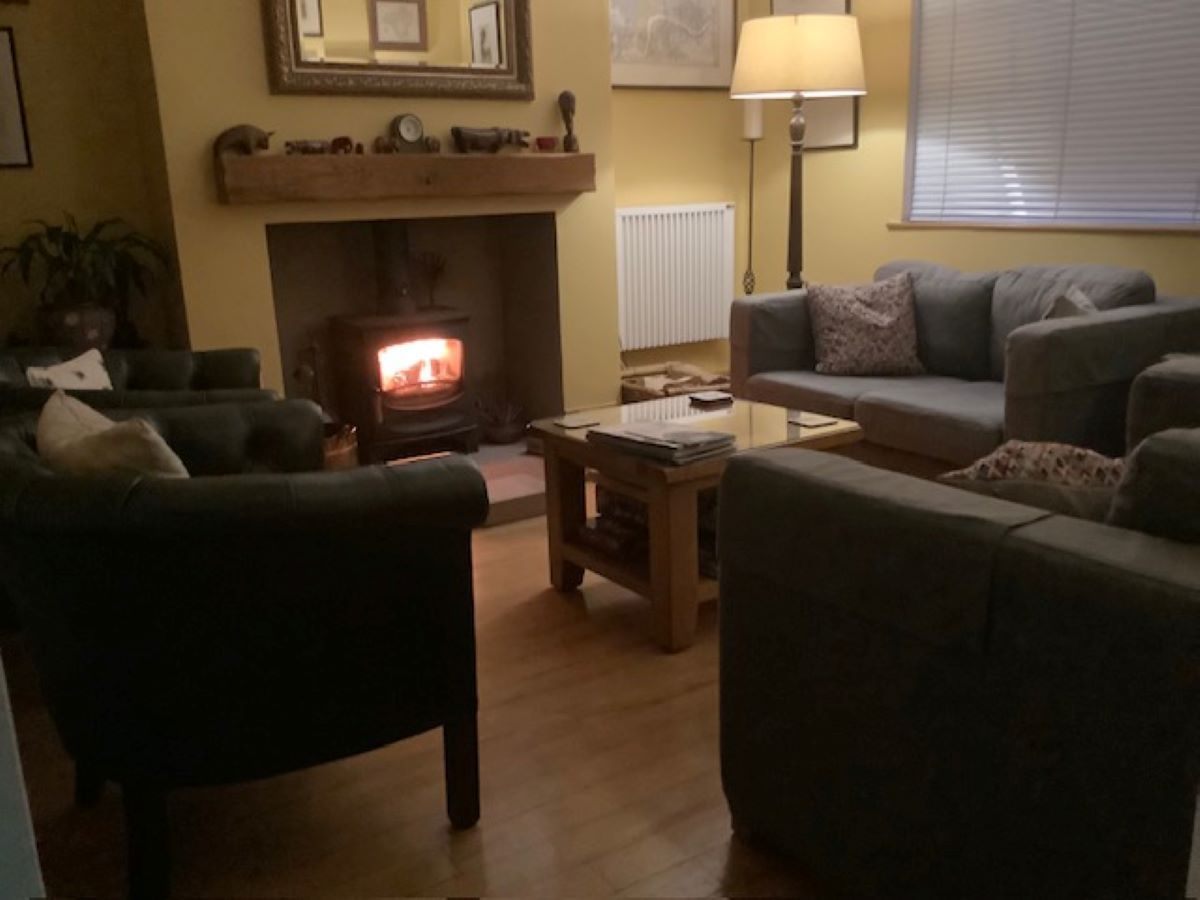 Cozy living room with sofas, armchairs, a coffee table, and a lit fireplace