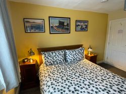 Kingsize bed, bedside tables and lamps and pictures above bed of Bedroom 3