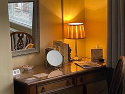 Dressing table/desk with books and mirror, and mirror on wall