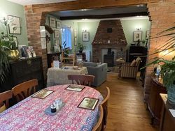 View of the Dining Room from the end of the room with the window at the front of the house -  Dining Table, comfy seating for guests and plants