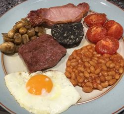 Fried Egg, homemade beef sausage slice, bacon, black pudding, mushrooms, tomatoes and baked beans