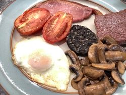 Fried Egg, homemade beef sausage slice, bacon, black pudding, mushrooms and tomatoes