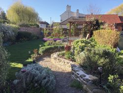 Path in garden at The Old Posthouse going to patio area and seating for guests