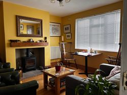 Snug with table for 2 for breakfast, chairs and sofa for guests' use and a log burner