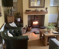 Fire in the log burner, comfy leather chairs, coffee tableand bookcase