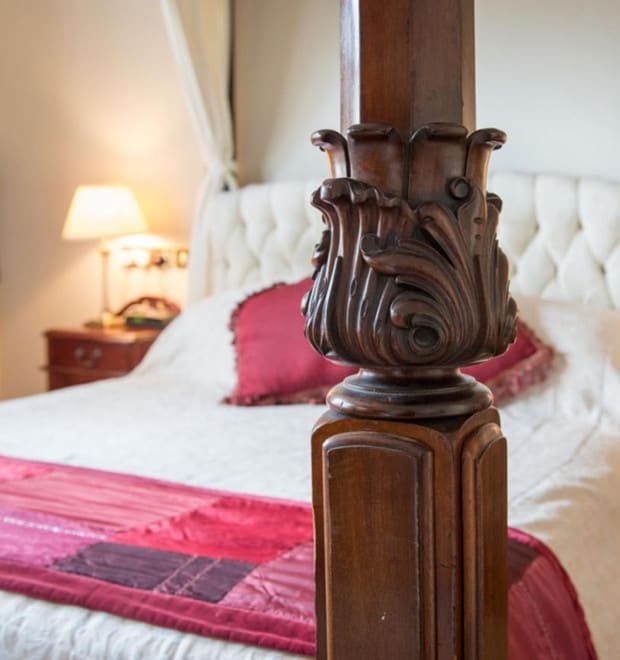 A close up of a four poster bed.