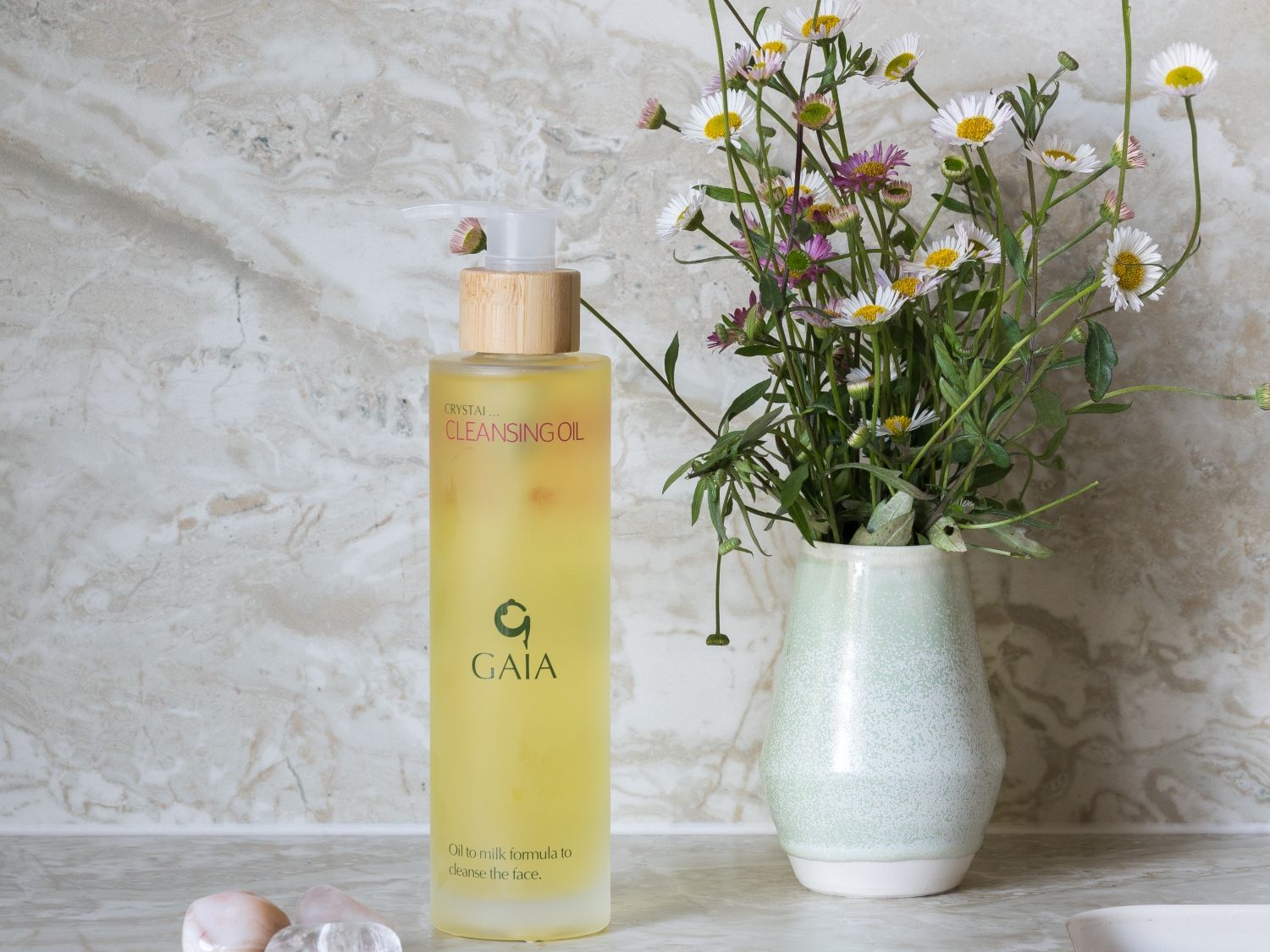 stones, cleansing oils and flowers in a vase
