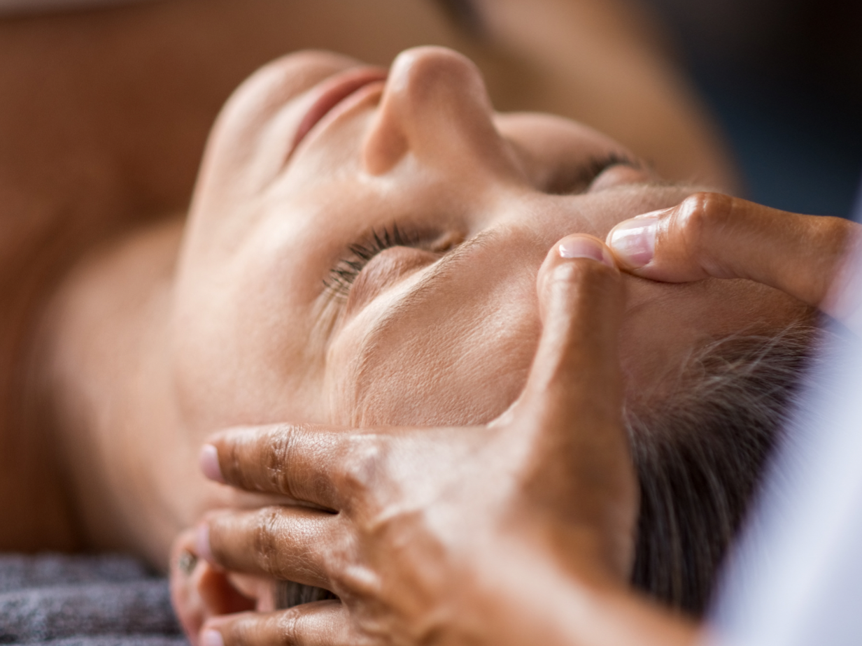 Woman receiving a pressure point facial
